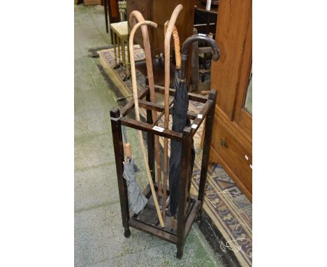 A 1940's oak stick stand; bentwood walking sticks; umbrellas.