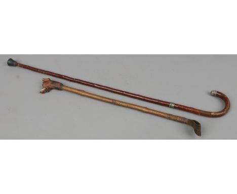 A walking stick with silver mounts and a riding crop, the handle carved in the form of a dogs head.