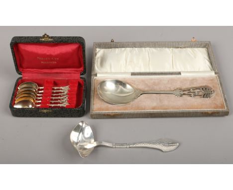 A group of silver plated wares including a George Jenson style ladle with planished decoration, a cased set of gilt demitasse