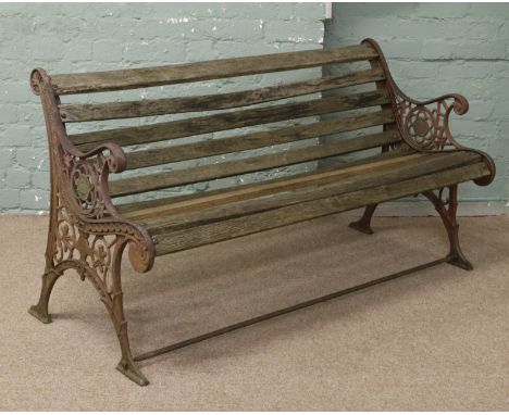 An antique cast iron bench with scrolling arms.