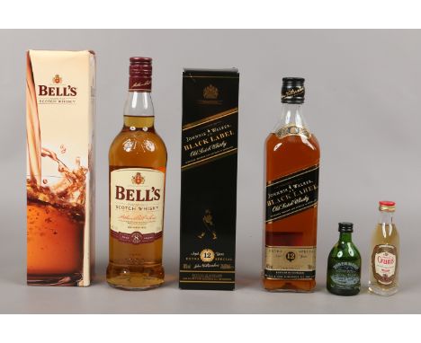 Two boxed 70cl bottles of Scotch Whisky, Bells and Johnnie Walker Black Label, along with two miniatures.