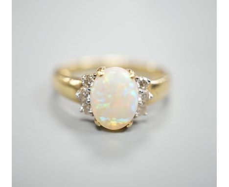 A modern 14k yellow metal, oval white opal and six stone diamond set cluster ring, size N, gross weight 2.9 grams.