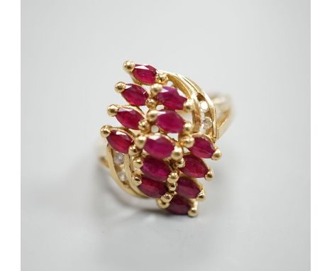 A modern 14k yellow metal ,ruby and diamond cluster set dress ring, size M, gross weight 5 grams.