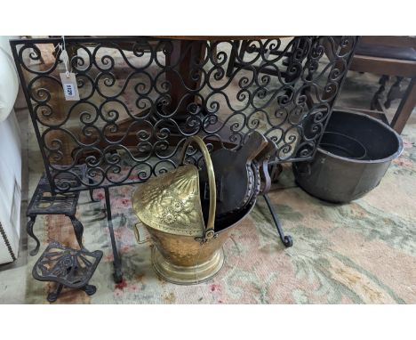 A wrought iron scroll work firescreen, width 95cm, a Dutch embossed brass scuttle, two trivets, coal bin and assorted metalwa