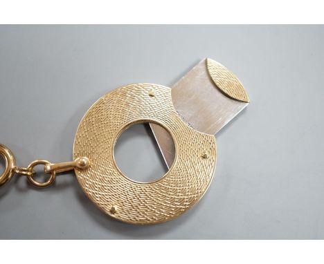 A 1960's engine turned 9ct gold mounted circular cigar cutter, 34mm, with gilt metal fob clip.