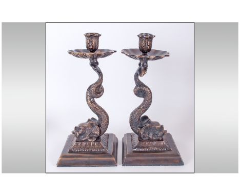 Pair of Bronze Dolphin Candlesticks, each base comprising the bewhiskered dolphin head resting on a decorated square low plin