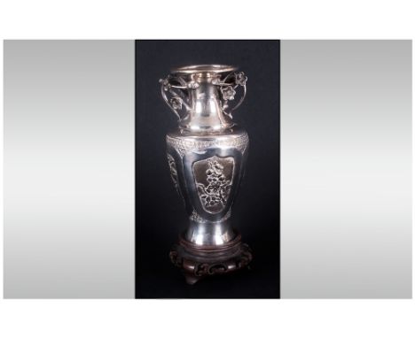Chinese Silver Two Handle Vase, raised on a carved wooden stand. Circa 1905-10, 95 grams. Silver. Stands 5.5'' in height.