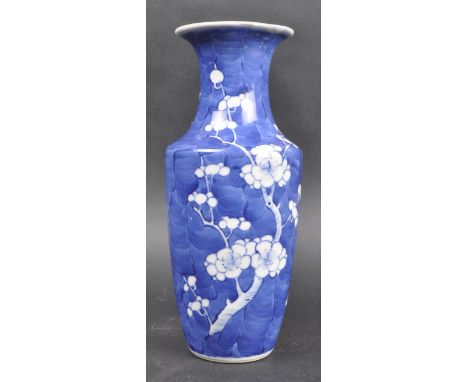 A 19th Century Chinese Kangxi Mark porcelain prunus pattern blue and white vase of baluster shape. Blue ground and white blos