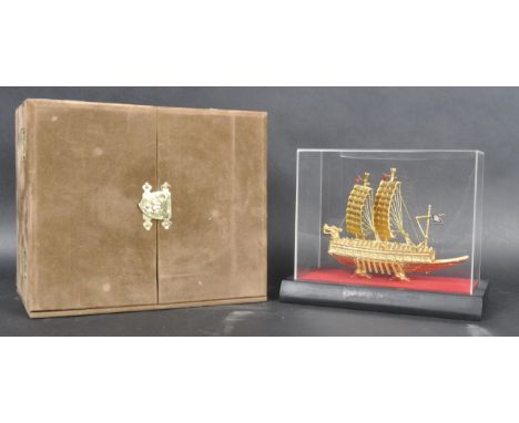 A miniature scale model of a Korean Turtle Ship, plated in 24k gold and contained within a perspex case and outer hinged box.