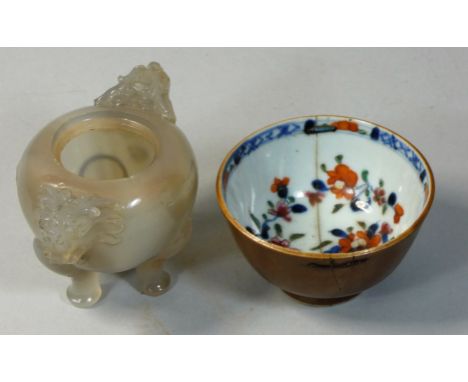 A Chinese carved jade pot, Quin Dynasty, with stylised dragon handles, raised on three pad feet, lacking cover and losses to 