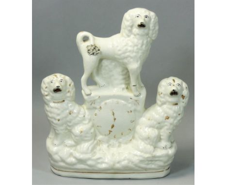 A Staffordshire Pottery group featuring a trio of Spaniels and a faux clock, with polychrome enamel decoration, height 24cm.