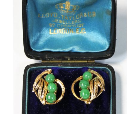 A 14K gold pair of jade ear rings, by J.A.W., composed of three cabochon stones with leaf surround, 5 gm, length 2cm, case.