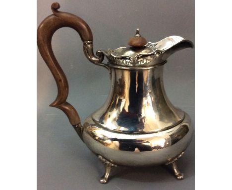 AN EARLY 20TH CENTURY HALLMARKED SILVER BALUSTER WATER JUG Having a scrolled and pierced spout, turned wooden handle and fini