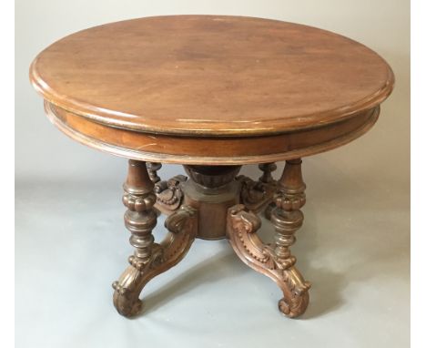 A 19TH CENTURY ANGLO-CHINESE HARDWOOD TABLE The circular top raised on turned supports over four scroll carved legs centred b