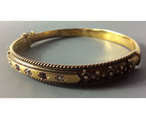 A VICTORIAN 15CT GOLD, DIAMOND AND RUBY BANGLE  Set with three round cut diamonds interspersed with two rubies and flanked by