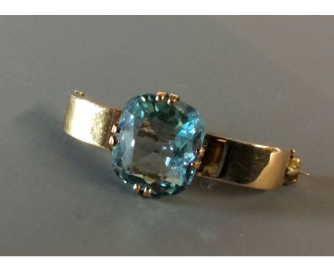 A VINTAGE 9CT GOLD AND AQUAMARINE SCARF CLIP Having a cushion cut aquamarine claw set and held in a convex shape clip. (l 3.3