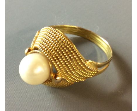 A VINTAGE 9CT GOLD AND PEARL SET RING Having a single pearl held in an unusual rope twist design (size O).