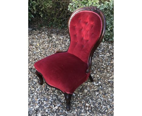 A VICTORIAN MAHOGANY FRAMED NURSING In red velvet button back upholstery.