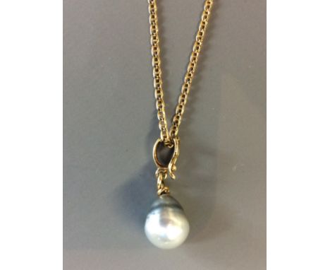 A 14CT GOLD AND GREY PEARL PENDANT DROP The pear shaped pearl set in a plain gold mount, suspended from a fine link chain.  (