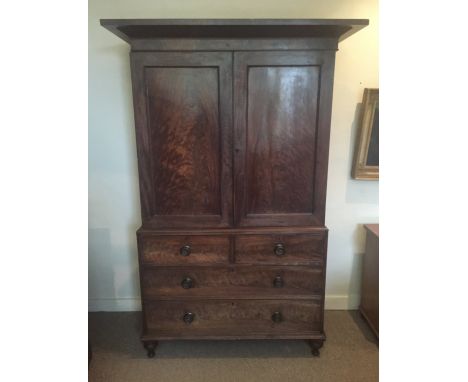 A WILLIAM IV PERIOD MAHOGANY LINEN PRESS with deep cushion cornice above flame panelled doors enclosing slides, with an arran