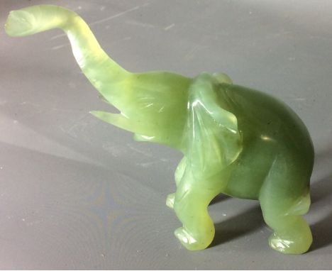 A 20TH CENTURY ORIENTAL JADE CARVING  An elephant with elongated raised trunk and large engraved ears. (approx 10cm x 10cm) 