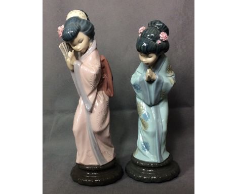 TWO 20TH CENTURY LLADRO PORCELAIN FIGURES A Geisha girl wearing a pink robe and hiding behind a fan, the other wearing a ligh