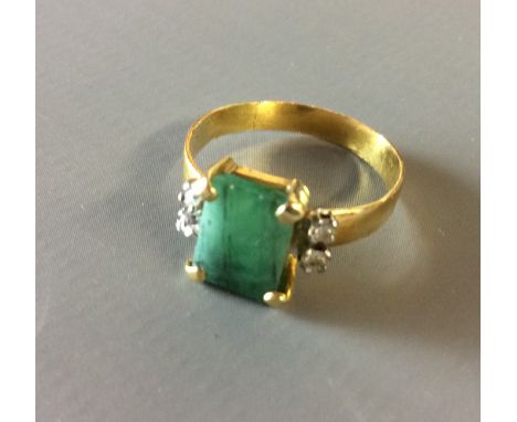 A VINTAGE 22CT GOLD, EMERALD AND DIAMOND RING  Having a single cushion cut stone flanked by two pairs of diamonds, marked '22