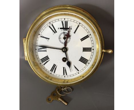 A LATE 19TH/EARLY 20TH CENTURY BRASS SHIP'S CLOCK The painted dial with Roman numeral chapter ring, secondary dial and fast/s