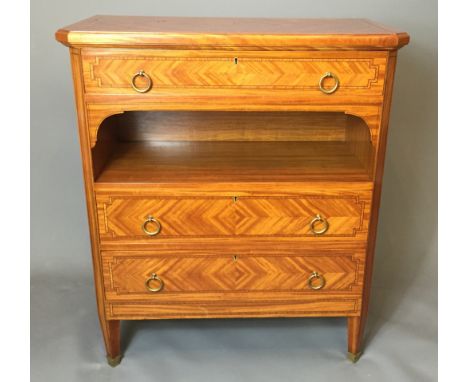 AN EARLY 20TH CENTURY SATINWOOD AND CROSSBANDED CHEST OF THREE LONG DRAWERS With canted corners and an open recessed shelf, r