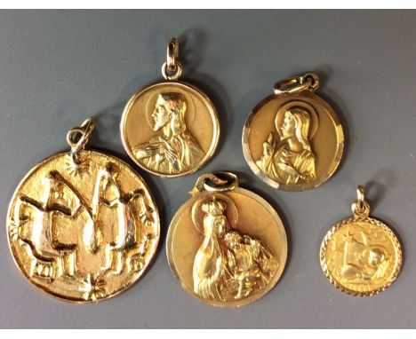THREE 9CT GOLD RELIGIOUS MEDALLIONS  Each having a portrait of Christ, together with a medallion cast with tribal style chara