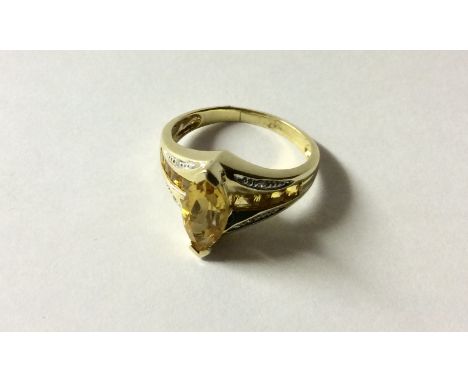 A HALLMARKED 9CT GOLD, CITRINE AND DIAMOND DRESS RING The marquis cut citirine claw set between two rows of square cut citrin