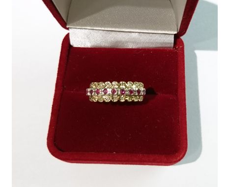 A HALLMARKED 9CT GOLD, RUBY AND DIAMOND HALF HOOP RING  The row of small round cut rubies claw set in white gold, between two