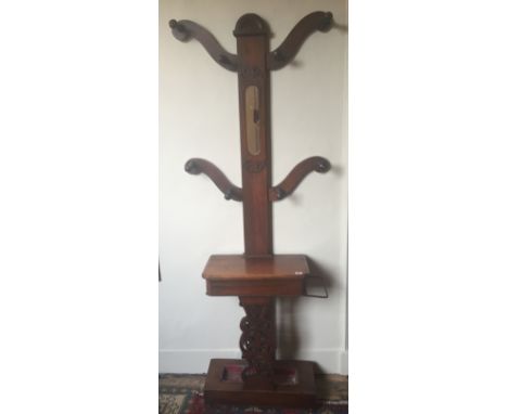 A LATE VICTORIAN MAHOGANY HALL STAND The mirrored and carved back flanked by four hanging branches over a hinged compartment 