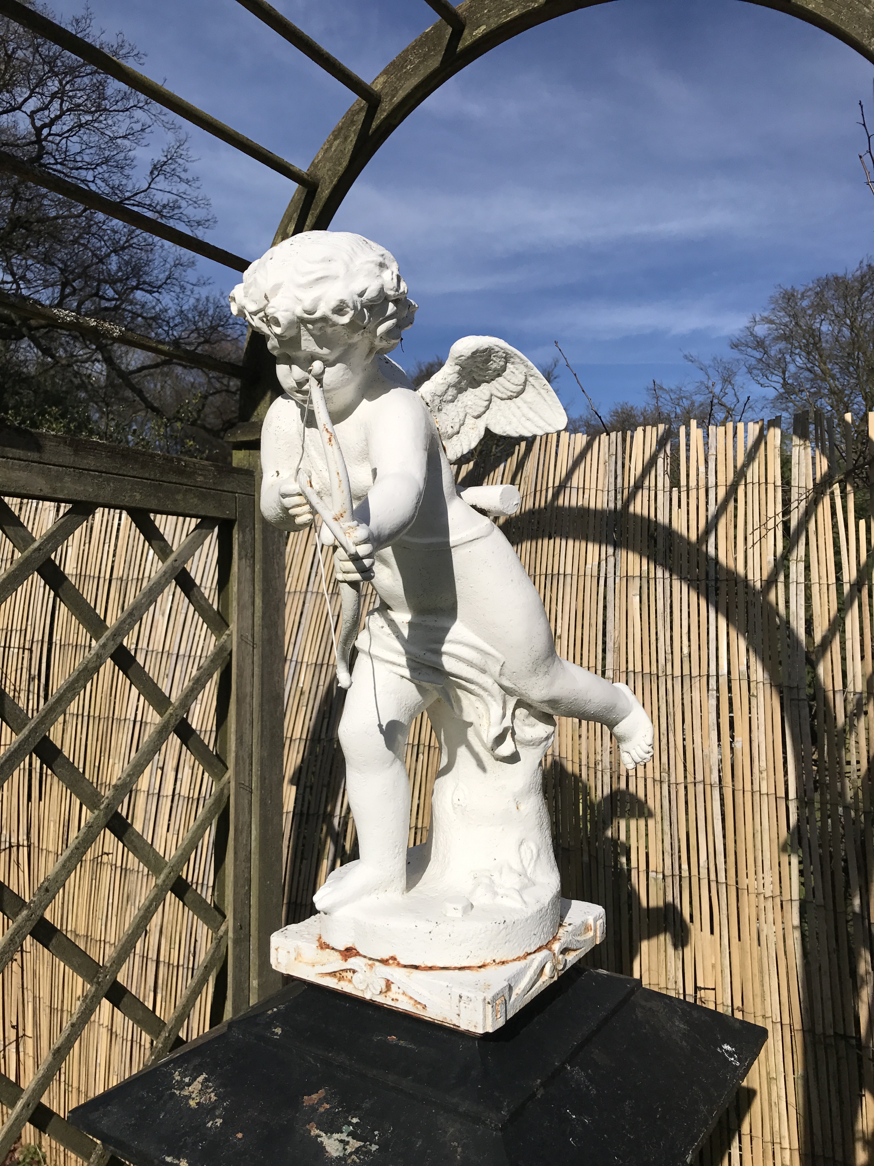 A VICTORIAN CAST IRON STATUE OF A WINGED CHERUB With bow and arrow