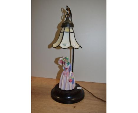 A continental porcelain figural table lamp, with a Tiffany style glass shade, measuring 51cm