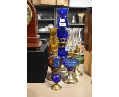 A vintage cobalt blue oil lamp, with pierced metal base, together with four other miniature oil lamps, the largest measures 3