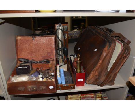 A vintage brown leather doctor's bag and assortment of medical equipment of similar age, to include a blood pressure monitor,