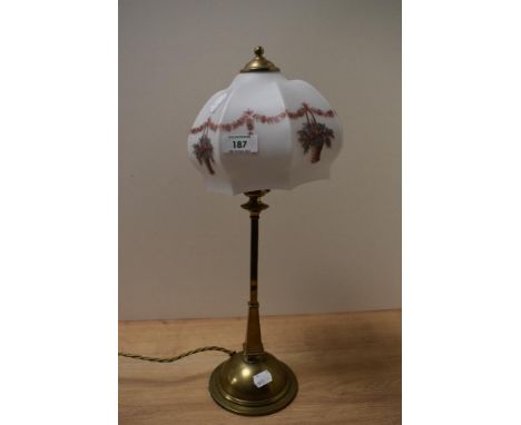 An Art Nouveau brass table lamp, the glass shade decorted with floral swags, and measuring 47cm tall