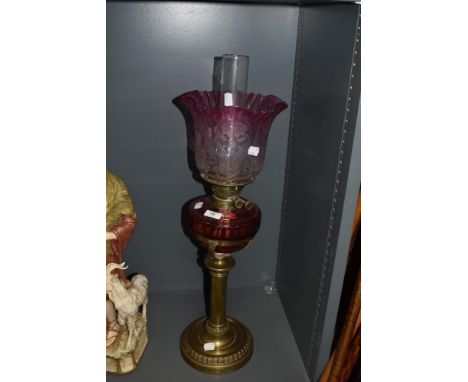 A Victorian oil lamp, having cranberry glass reservoir and etched cranberry tinged fluted shade.
reservoir removable, shade i