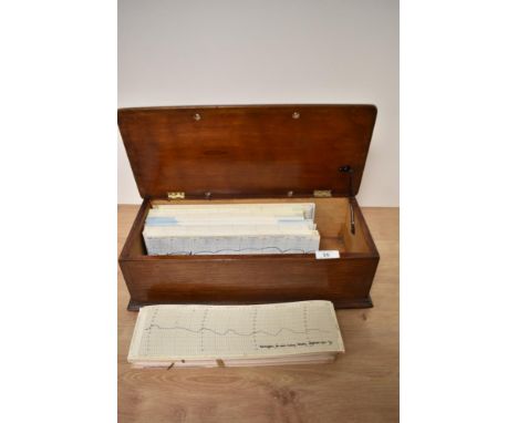 A collection of vintage barograph charts in wooden box.