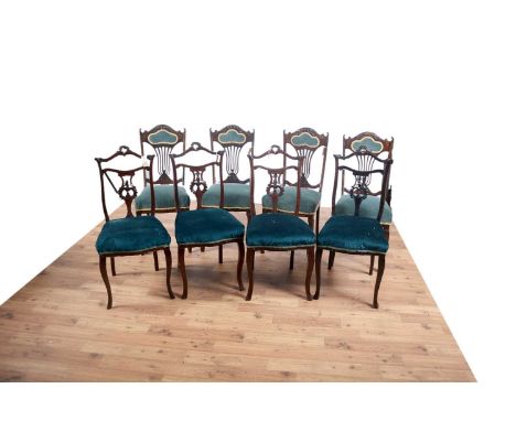 A set of four carved mahogany dining chairs, the carved and padded backrest with pierced and carved spats above padded seat p