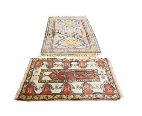 Two Turkish rugs, the first of geometric design on a red field within a repeating border, 230 x 123cms the second with an ivo