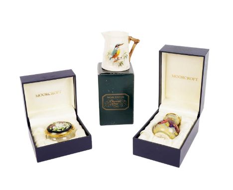 A Moorcroft miniature enamel vase, decorated with grapes and pomegrantes, with a gilt coloured rim, in its box, 6cms high; to