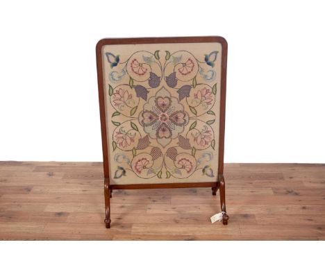 An early 20th Century tapestry fire screen, with rounded frame, cream, pink, blue and green floral tapestry, raised on four d