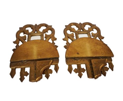 A pair of late 19th/early 20th Century gilt gesso wall brackets, each with a rectangular mirror plate within a pierced border