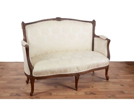 A Victorian carved mahogany sofa, the foliate carved frame with flower and ribbon cresting, with padded arms and foliate carv