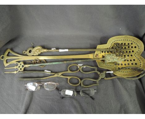 A selection of fire side items including brass poker tongue set and fork