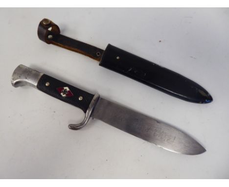 A German Nazi Hitler Youth knife, an emblem on the handle, the blade with a motto&nbsp; 5.5"L, in a black steel sheath, on a 