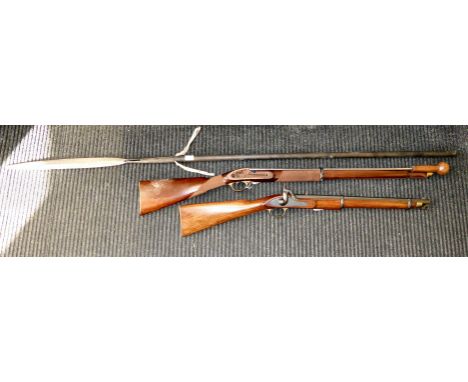 A 19thC style percussion action rifle with a ramrod; a similar rifle stock; and a modern reproduction of a native spear with 