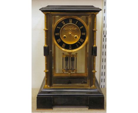 A late Victorian four glass and black slate cased mantel clock with bevelled panels, integral, outset and ring turned spindle